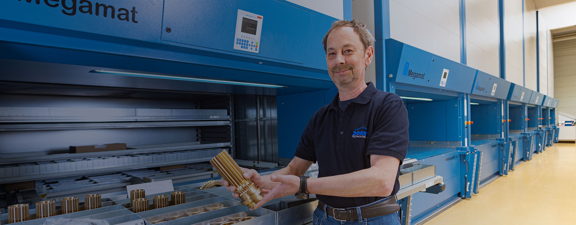 DORST Technologies employee with spare part in front of Megamat storage system